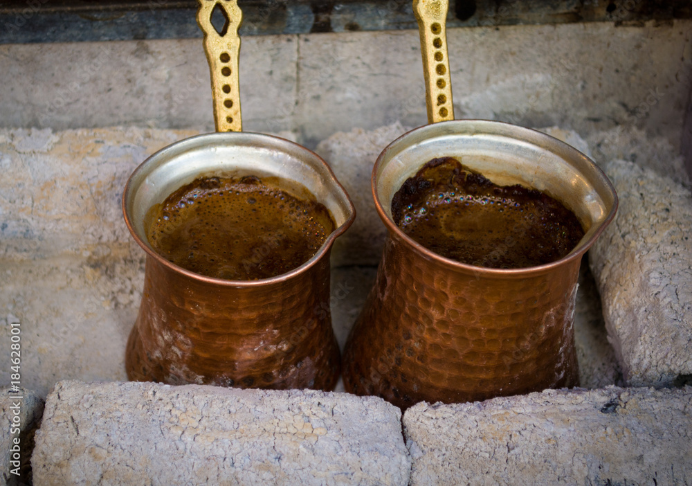 preparing coffee in pots on hot coals