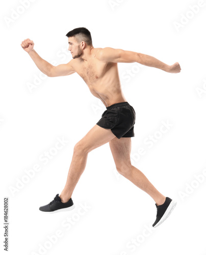 Handsome young man running against white background