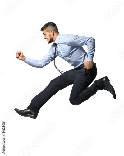 Young man in formal clothes jumping against white background © Africa Studio
