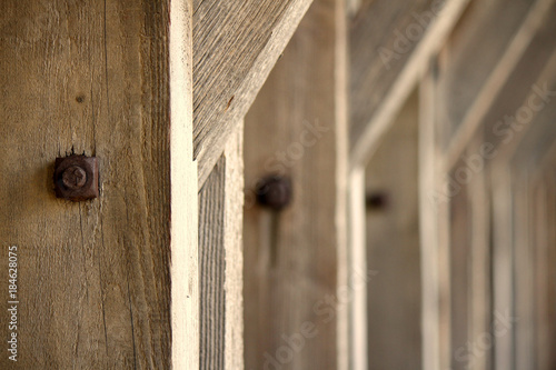 Row of identical Wooden Beams with Rusty Screws Construction Supporting a Roof photo