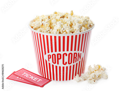 Cup with popcorn and cinema tickets on white background