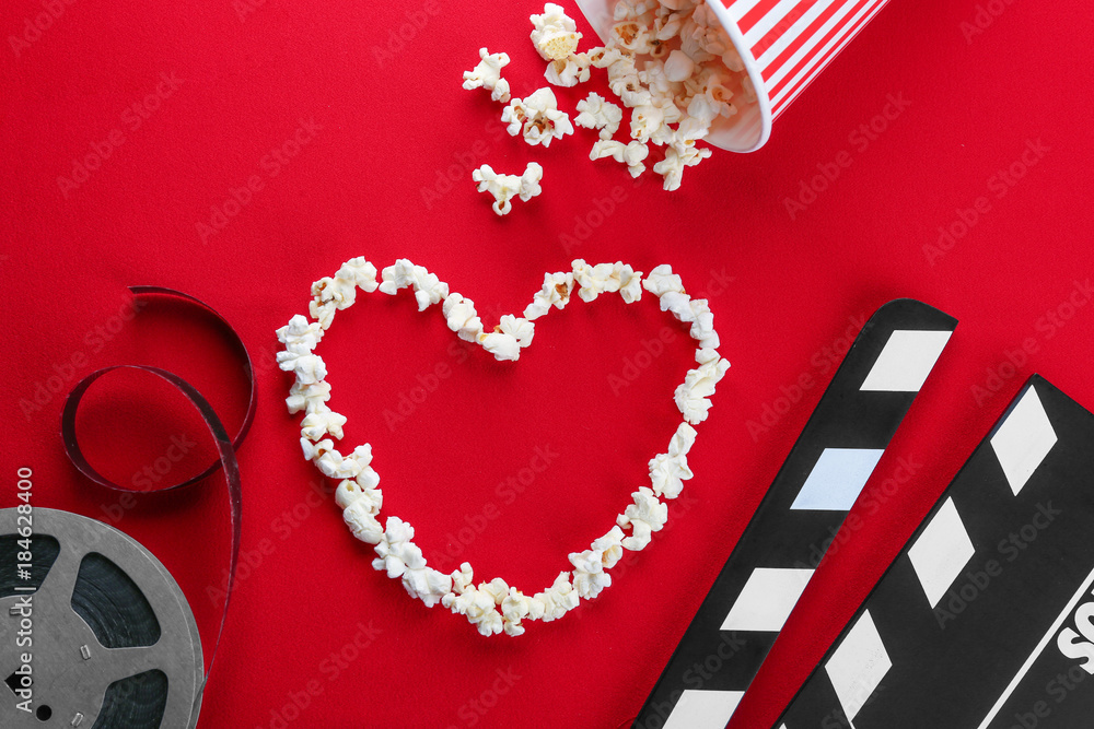 Fotografie Composition with popcorn and cinema film on color background