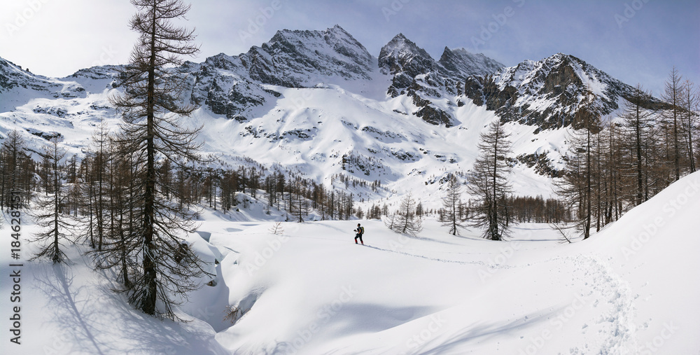 winter mountains landscape panorama with man trekking. Italian Alps