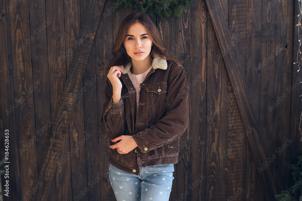 Portrait beautiful girl with long hair in warm winter clothes on wooden background.