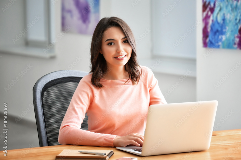 Young woman using laptop in office Young woman using laptop in office