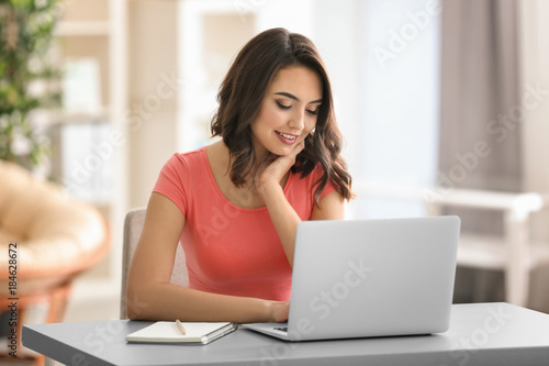 Young woman using laptop wh...