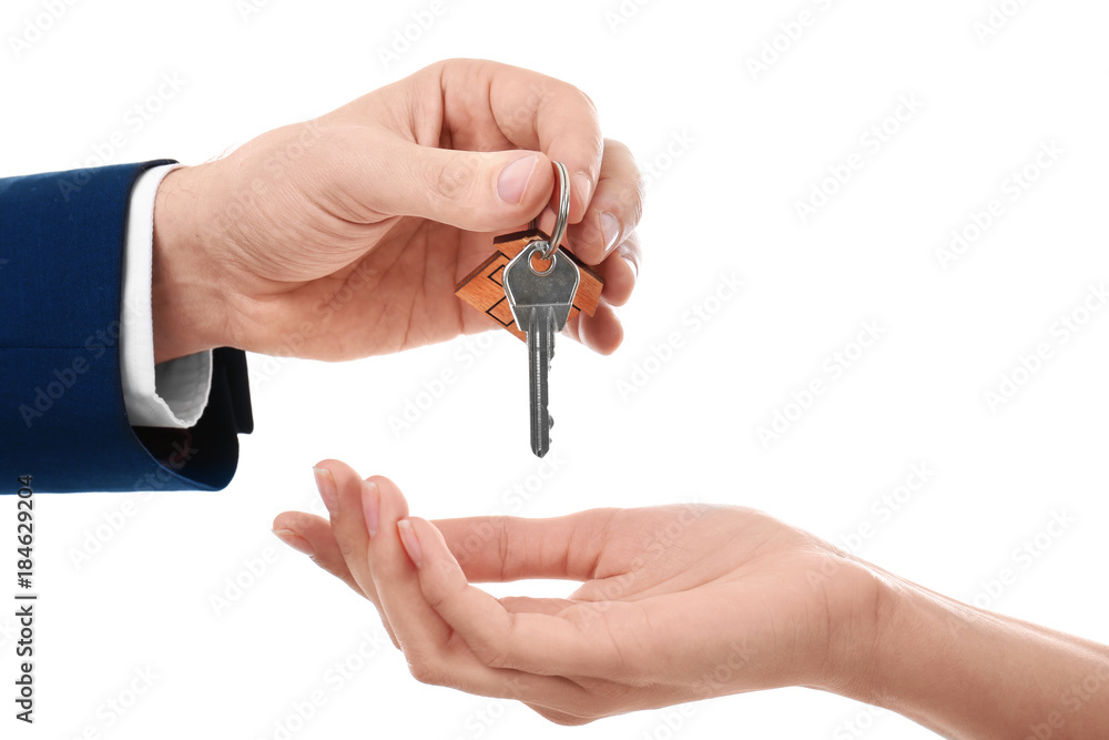 Real estate agent giving key of new house to woman on white background Real estate agent giving key of new house to woman on white background