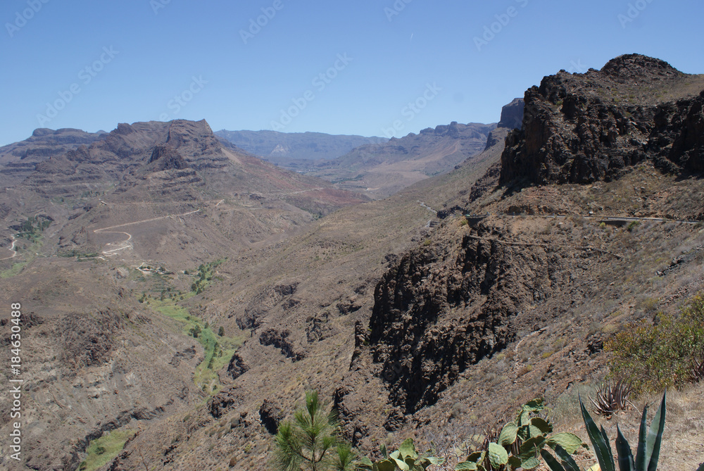 Arid canyon and barren landscape with vegetation in the river valley. Gran Canaria
