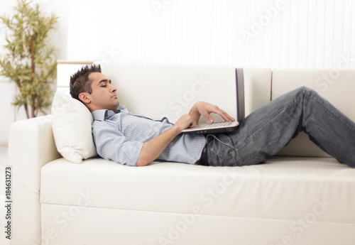 guy with laptop lying on the sofa