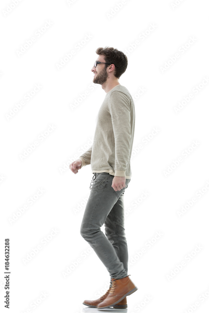 Side view.Young smiling man walking forward Side view.Young smiling man walking forward