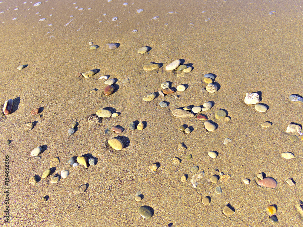 Small round cobblestones washed on sunny beach closeup. Small round cobblestones washed on sunny beach closeup.