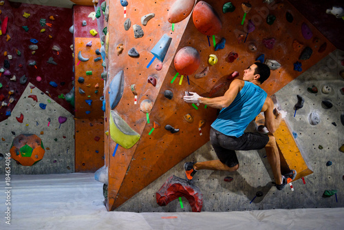 Man climber in bouldering gym.Indoor workout exercise.