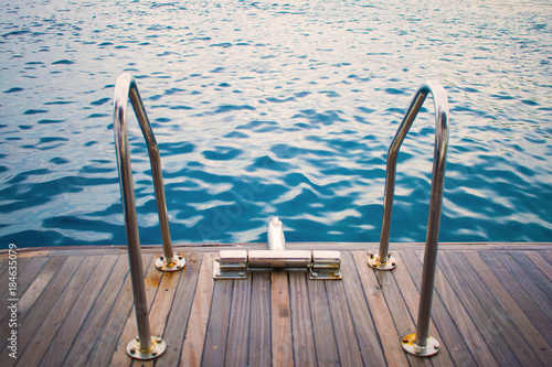 view of the yacht's gangway against the azure sea. relax. swimming. wooden deck and gangway