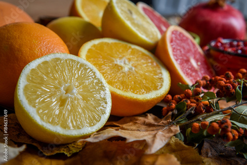 Tropical fruits with mix of lemons, oranges, grapefruit, pomegranate on a vintage wooden board