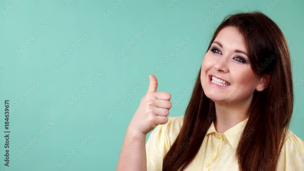 Young happy smiling woman making thumb up gesture showing cool sign, green background. Satisfaction success symbol 4K ProRes HQ codec Young happy smiling woman making thumb up gesture showing cool sign, green background. Satisfaction success symbol 4K ProRes HQ codec