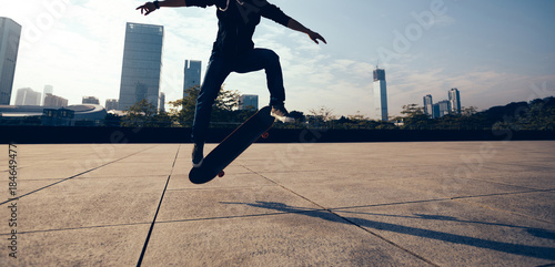 female skateboarder doing a hand on skateboard in city photo