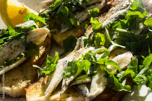 Anchovis auf Knoblauchbrot mit Salat als Vorspeise photo