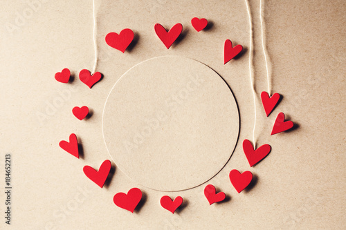 Handmade small paper hearts with strings on erthy colored paper background