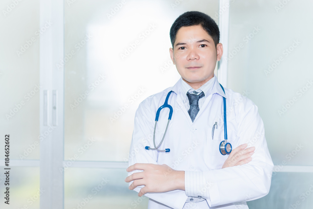 Smiling doctor posing with arms crossed in the office Smiling doctor posing with arms crossed in the office