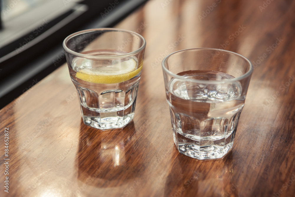 water and lemon with cup(glass) on the wood table. water and lemon with cup(glass) on the wood table.