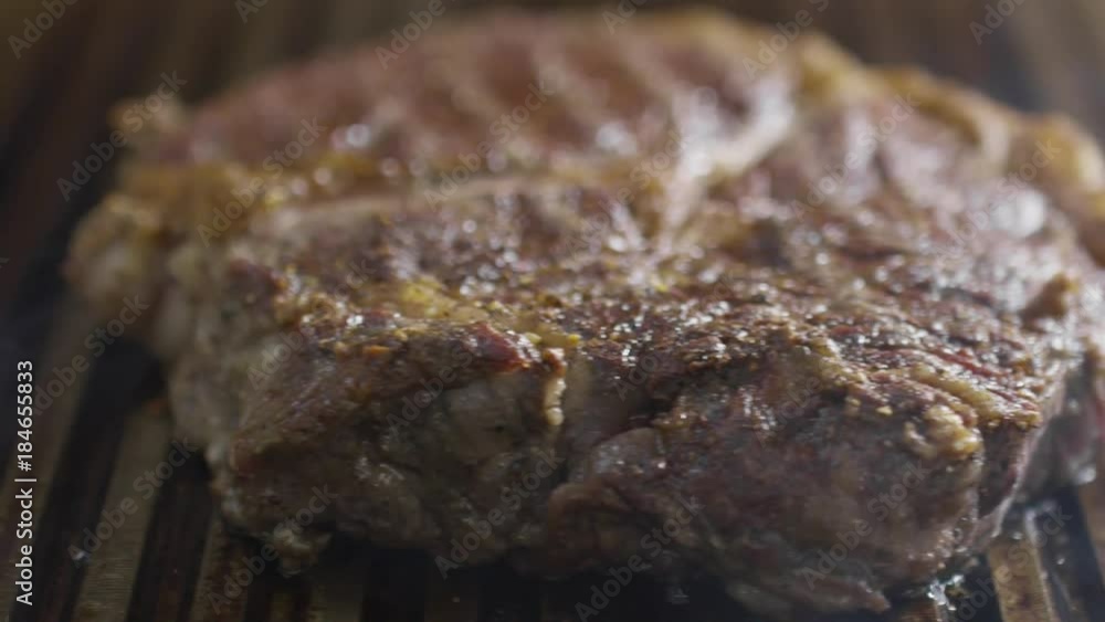 Closeup tracking shot of cooking meat steak on hot grill Closeup tracking shot of cooking meat steak on hot grill