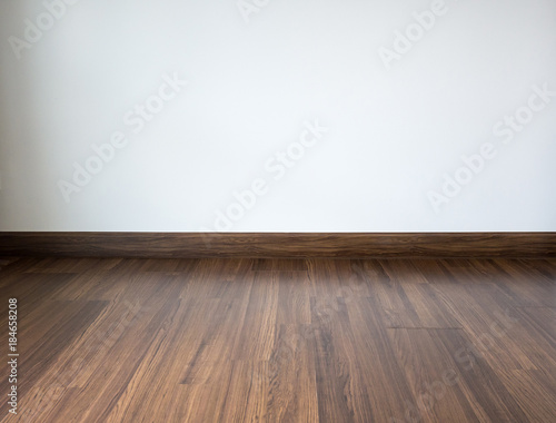 Empty room with laminate floor and white wall background © Piman Khrutmuang