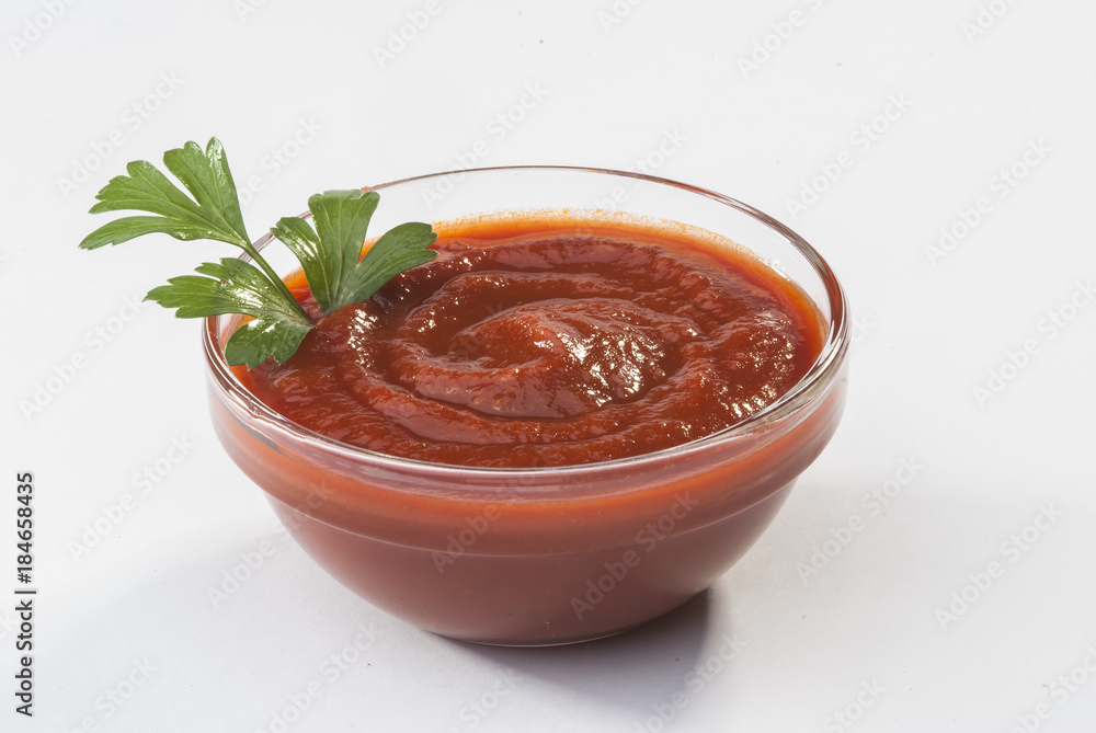 Fresh red tomato salsa in white bowl with mint and parsley on white background Fresh red tomato salsa in white bowl with mint and parsley on white background