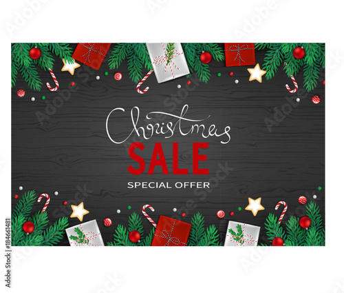 Christmas discount Sale horizontal banner with fir branches, paper gift boxes, candy cane,  cookies, lollipops, balls on a black background. Big seasonal sale. Special offer. Top View.
