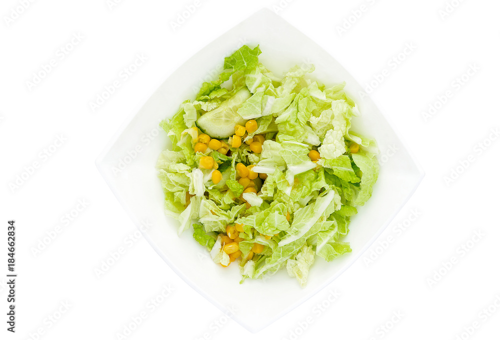 Vegetable salad of cabbage, corn and cucumber in the white plate isolated Vegetable salad of cabbage, corn and cucumber in the white plate isolated