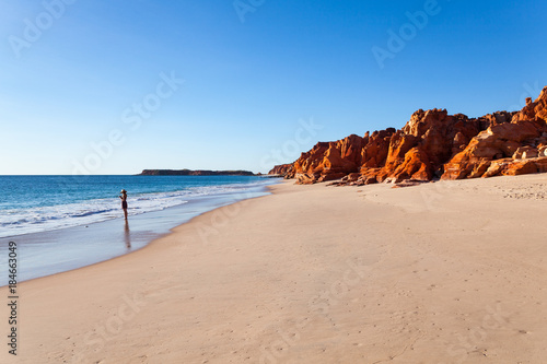 A girl stands at Cape Leveque. Cape Leveque is the northernmost tip of the Dampier Peninsula in the Kimberley region of Western Australia. Cape Leveque is 240 kilometres north of Broome. photo