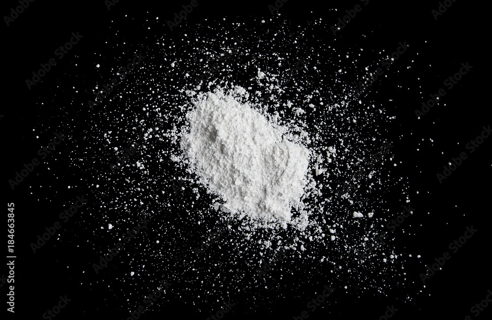 White powder isolated on black background, dust or powder texture