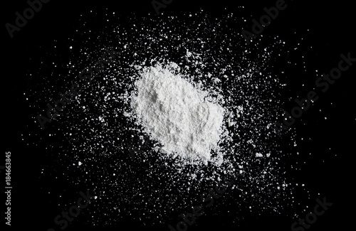 White powder isolated on black background  dust or powder texture