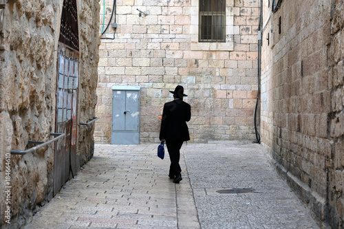 One unrecognized religious jewish man walking down the street in Old City of Jerusalem.