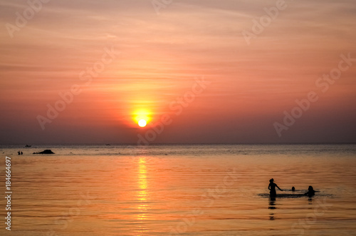 young people swimming in sunset atmosphere