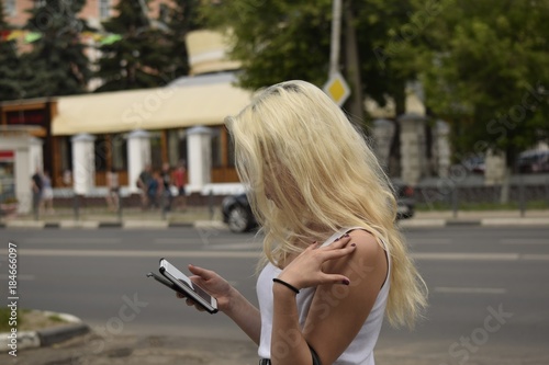 Young girl with phone in hand always online in the city