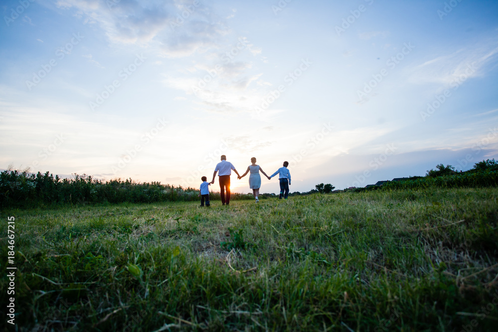 Happy family on the background of the sunset