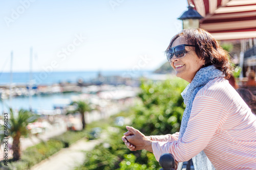 Beautiful elderly woman admiring the landscape on the shores of the Mediterranean Sea. Holidays and travel in retirement, active seniors