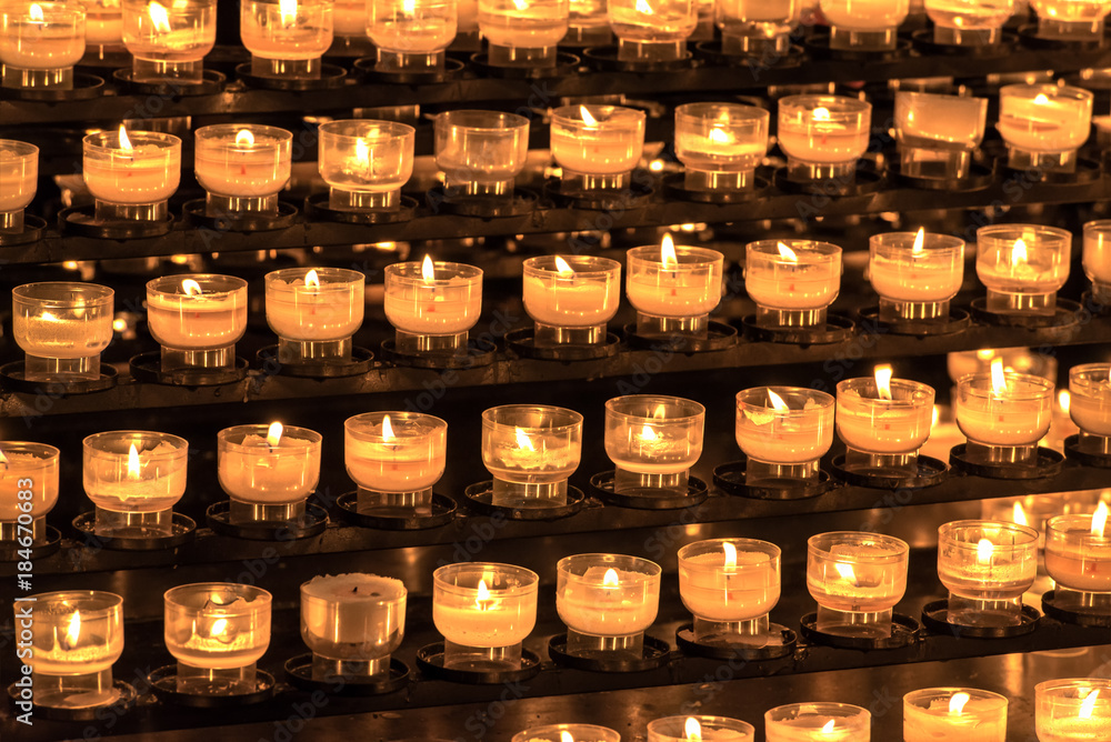 Church candles. Christmas candles or memorial candle or ceremony candle burning in the church. Abstract candles background with a golden light of candle flame. Concept: religion Church candles. Christmas candles or memorial candle or ceremony candle burning in the church. Abstract candles background with a golden light of candle flame. Concept: religion