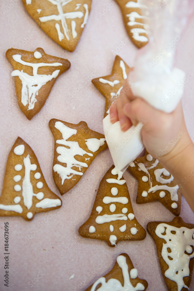 Kid decorates Christmas cookies