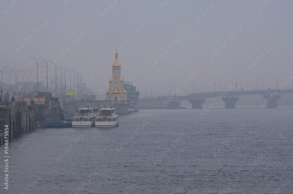 View to the embankment near the river port. City landscape. Kyiv, Ukraine. Misty winter morning