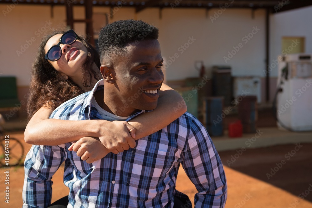 Man giving a piggyback ride to woman Man giving a piggyback ride to woman