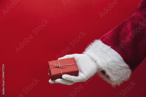 Santa Claus hand holding a Christmas present