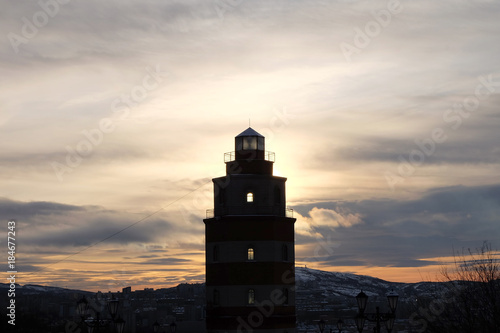Memorial lighthouse with sunrise background background on the hill in Murmansk