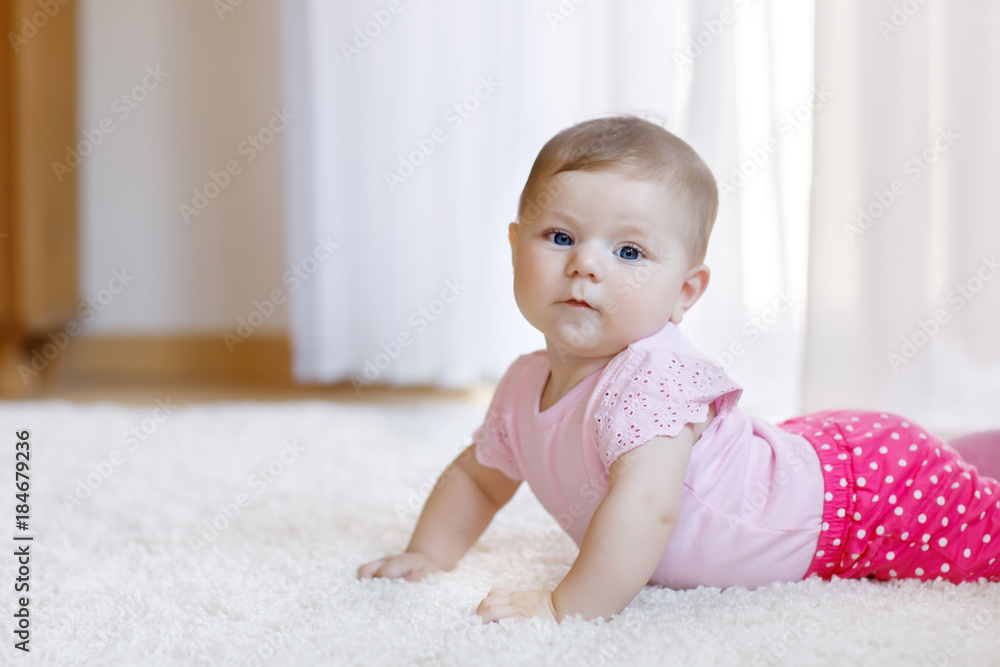Portrait of baby girl in white sunny bedroom. Newborn child learning crawling. Portrait of baby girl in white sunny bedroom. Newborn child learning crawling.