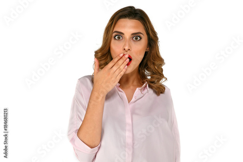 Wondered surprised business woman covering her mouth by the hands with curly hair  dressed up in blouse  on white background