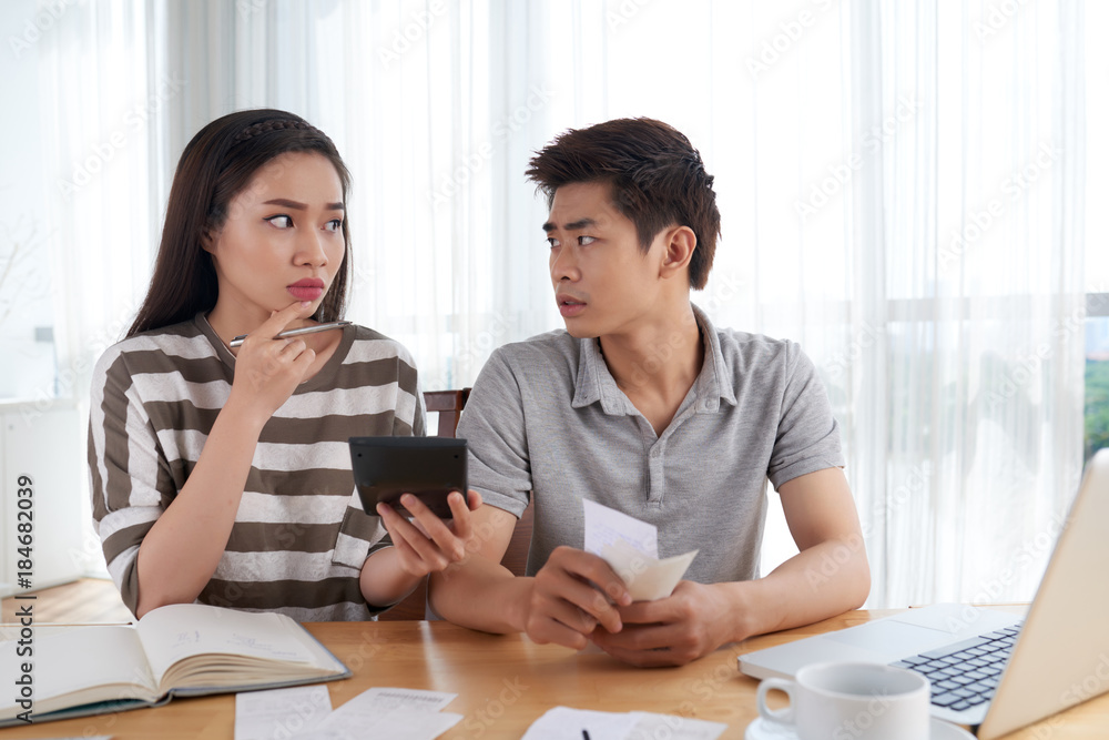 Unhappy Young Family Calculating Expenses Unhappy Young Family Calculating Expenses