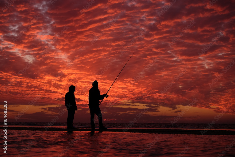 Fishermen under red sky