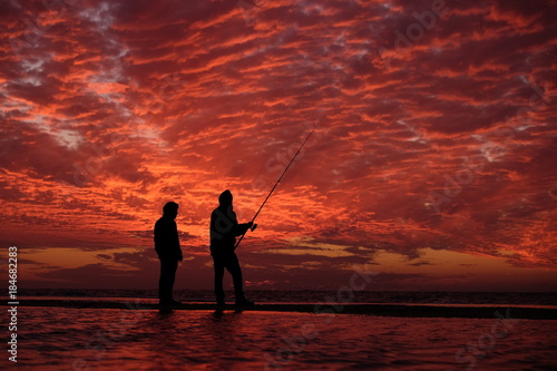 Fishermen under red sky