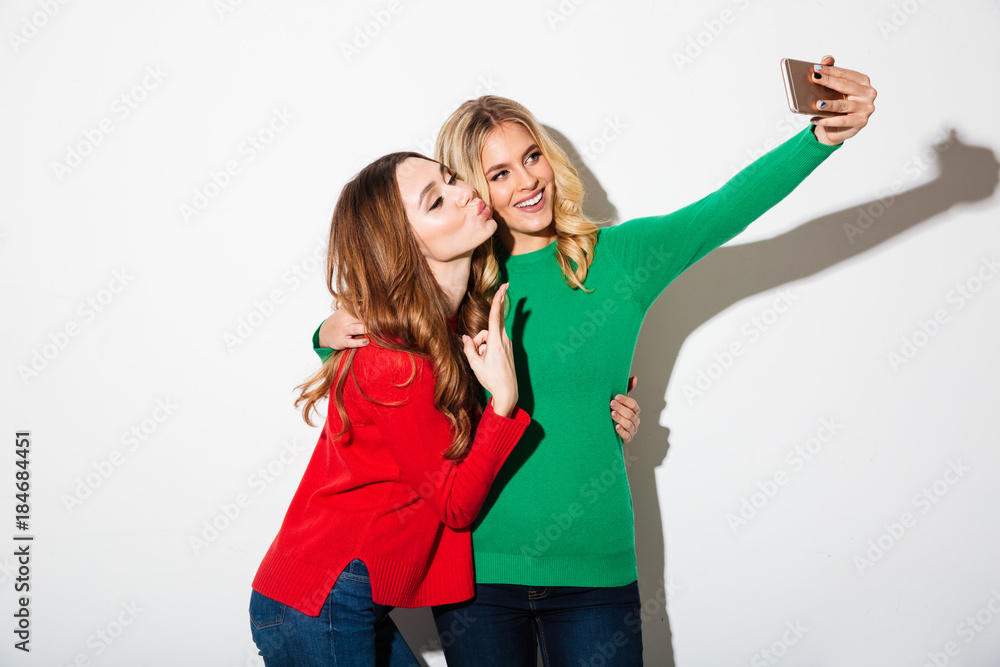 Portrait of two smiling girls dressed in sweaters Portrait of two smiling girls dressed in sweaters