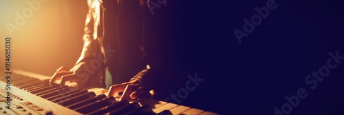 Mid section of musician playing piano photo